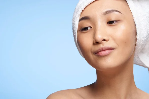 Aziatische vrouw naakt schouders en een handdoek op haar hoofd close-up — Stockfoto