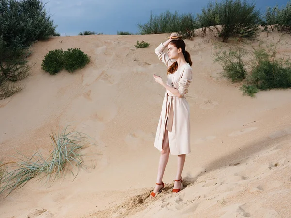 Romantische Frau mit Kamm im weißen Kleid und roten Schuhen steht im Sand — Stockfoto