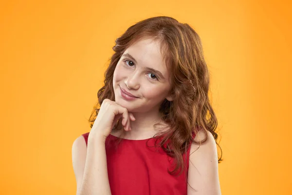 Chica con el pelo rizado vestido rojo divertido emociones de la infancia fondo amarillo —  Fotos de Stock