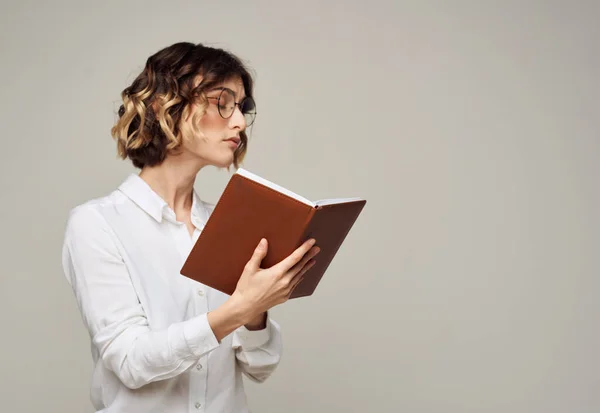 Επιχειρηματίας με ένα βιβλίο στα χέρια της σε γκρι φόντο. — Φωτογραφία Αρχείου