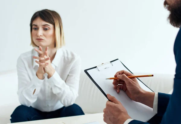 Uma mulher no sofá de um psicólogo na recepção e um homem com documentos — Fotografia de Stock