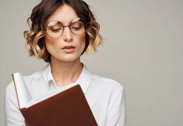 Chytrá žena s notebookem v rukou a v bílé košili na šedém pozadí oříznutý pohled — Stock fotografie