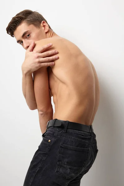 Een man met een naakt lichaam staat met zijn rug poseren aantrekkelijk soort levensstijl — Stockfoto
