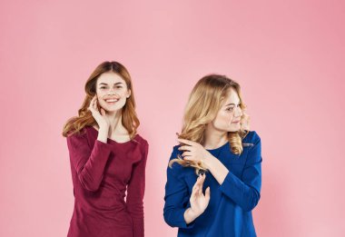 Zarif kadınlar yaşam tarzı stüdyo tarzı pembe arka plan giyerler.