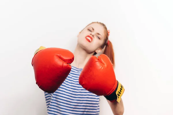 Boxer femme dans un t-shirt et en gants rouges coiffure maquillage fond clair — Photo