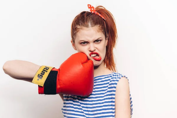 Mujer en camiseta a rayas y en guantes de boxeo rojo deporte de agresión — Foto de Stock