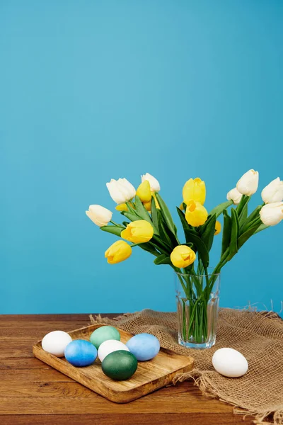 Bouquet de fleurs Pâques oeufs décoration vacances fond bleu — Photo