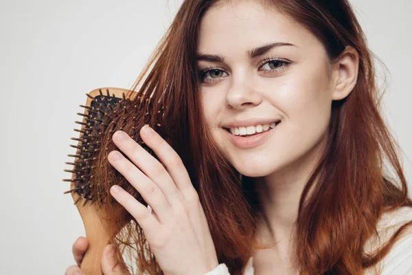 Modelo mujer con peine cabello sano en fondo claro bata blanca — Foto de Stock