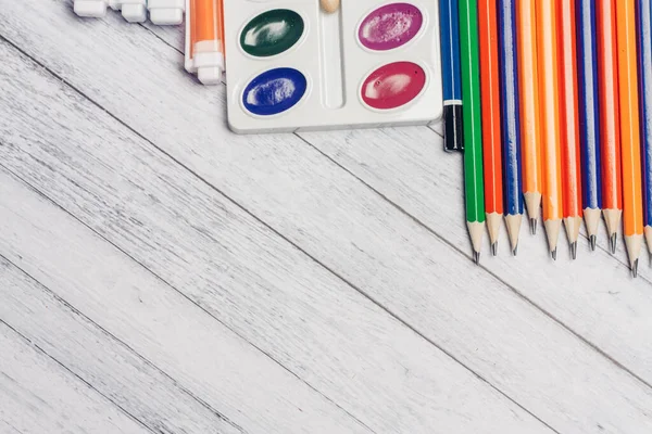 Цветные карандаши акварельные краски и маркеры ручки на деревянный стол школьного образования — стоковое фото