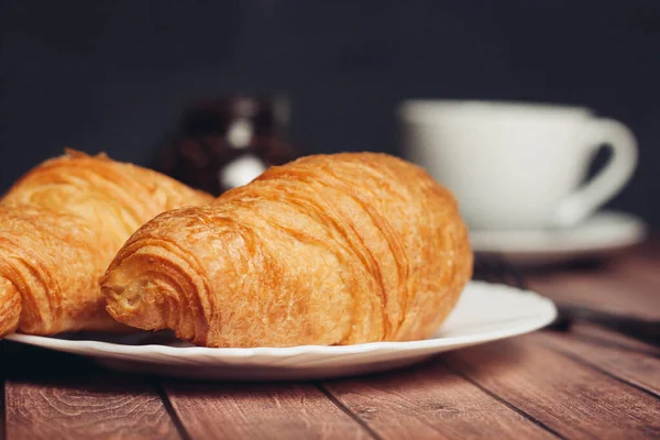 Croissanter tallrikar på trä bord kök frukost färsk lukt — Stockfoto