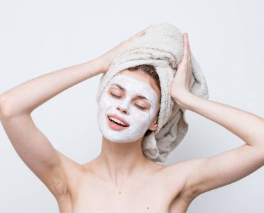 Çıplak omuzlu güzel bir kadın krem maskeli cilt bakımlı