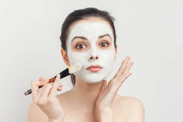 Mujer con hombros desnudos aplicando cepillo de maquillaje en el procedimiento facial —  Fotos de Stock
