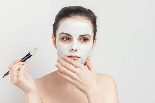 Morena con crema mascarilla cuidado de la piel cepillo aplicar maquillaje —  Fotos de Stock