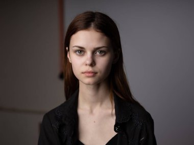 Gri arka planda kızıl saçlı bir kadının portresi. Güzel bir yüz modeli.