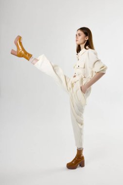 Bacağını kaldırmış güzel bir kadın. Ruj stüdyosu izole edilmiş.