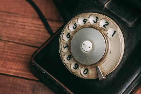Retro telefone preto em um clássico piso de madeira — Fotografia de Stock