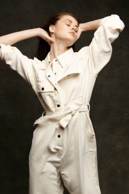 Önlüklü bir lider ellerini başının arkasında tutar ve arkasını yaslar.