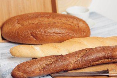 Tahta bir masanın üzerinde ekmek, mutfak bıçağı, kahvaltı.