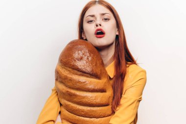 Parlak makyajlı neşeli bir kadın elleriyle bir somuna sarılıyor.