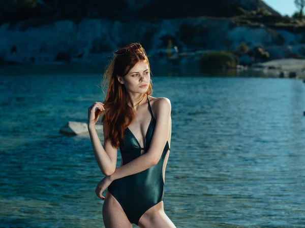 Vrouw in groen badpak staat in transparant water rivier zonnebril model — Stockfoto