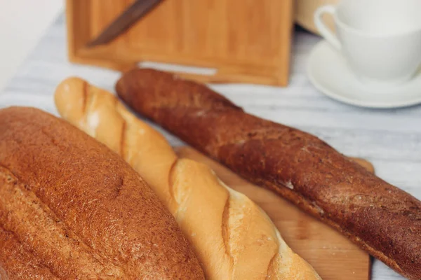 Pães frescos em uma cesta de pão no café da manhã de mesa — Fotografia de Stock