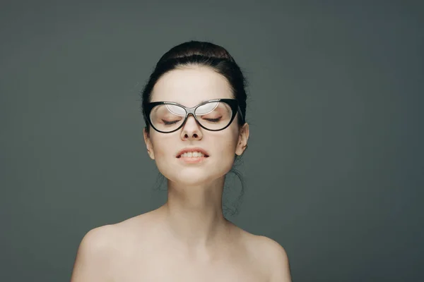 Attraente donna con spalle nude indossando occhiali glamour moda sfondo grigio — Foto Stock