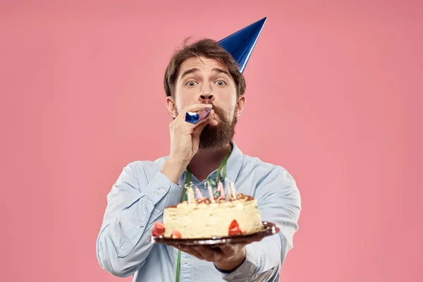 Man met taart in een bord en in een blauw shirt op een roze achtergrond verjaardagen bijgesneden uitzicht — Stockfoto
