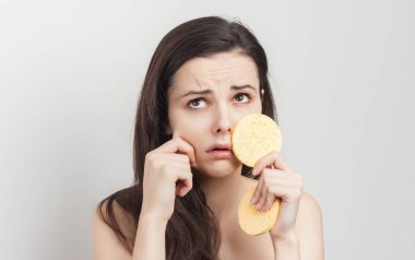 Esmer, dalgalı saçlı, çıplak omuzlu, cilt bakımlı.