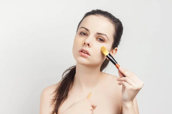 Emotionale Brünette mit nackten Schultern kosmetische Bürste in der Hand Hautpflege — Stockfoto