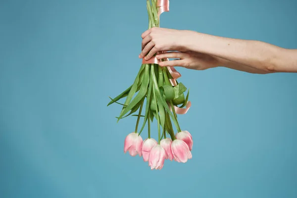 Буке в жіночих руках з подарунком День святого Валентина синій фон — стокове фото