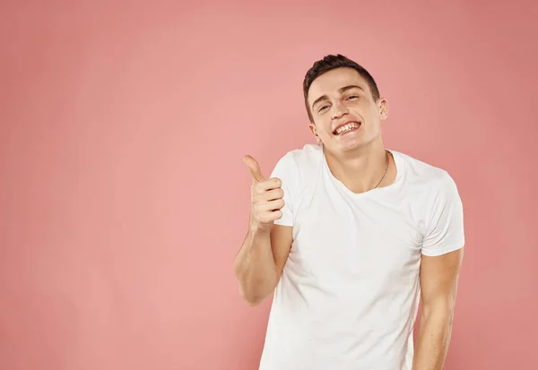 Schöner Mann im weißen T-Shirt Lifestyle Emotionen rosa Hintergrund — Stockfoto