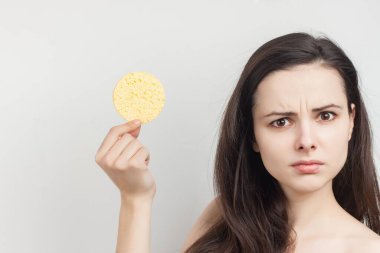 Esmer, dalgalı saçlı, çıplak omuzlu, cilt bakımlı.