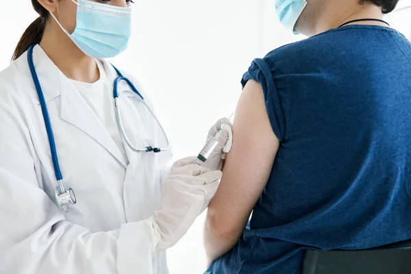Donna medico che effettua un'iniezione nella spalla paziente assistente di laboratorio vaccino epidemia — Foto Stock