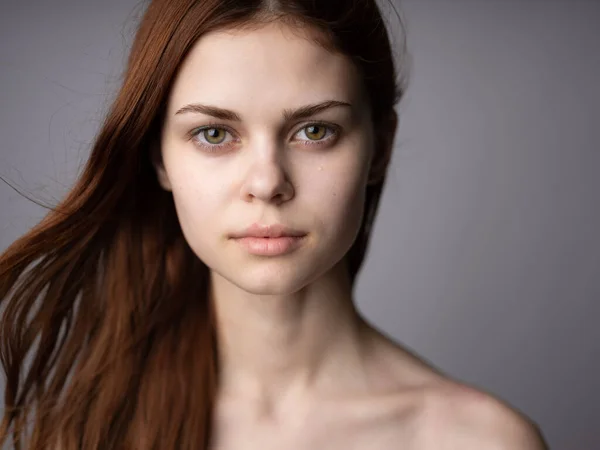 Portret van een mooie vrouw close-up rood haar grijze achtergrond Mode — Stockfoto
