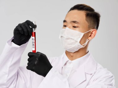 Asyalı görünüşlü adam. Siyah eldiven. Kan testi araştırması. 