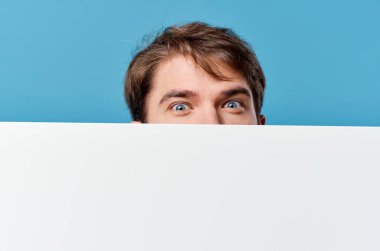 Pankartın arkasından bakan adam kırpılmış görüntü reklam alanı fotokopisi mavi arkaplan