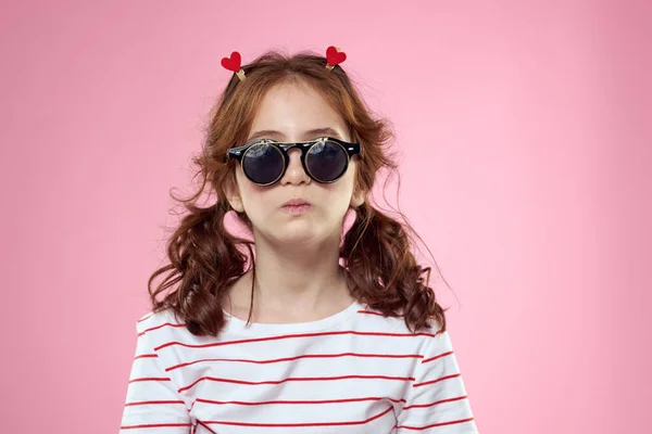 Fille à la mode avec des pinces à linge sous la forme de coeurs sur sa tête et des lunettes sur son visage — Photo