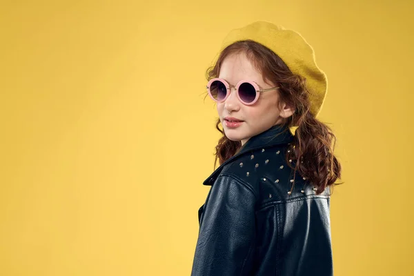 Meisje met een gele hoed donkere bril modieuze kleding studio levensstijl kindertijd — Stockfoto