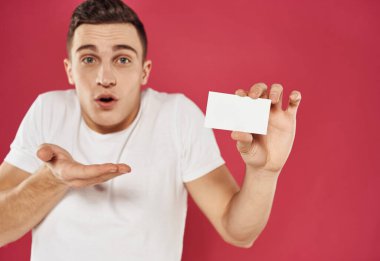 Elleri kırmızı arkaplanda el kol hareketi yapan bir adam.