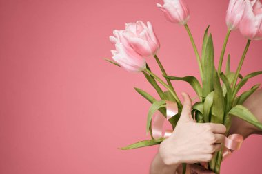 Çiçek buketi hediye olarak 8 Mart 'ta pembe arka planda