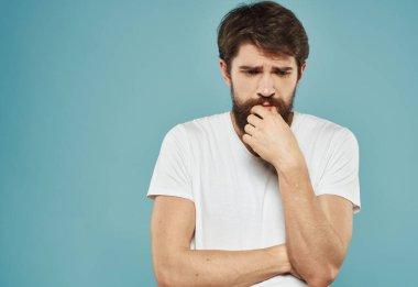 Mavi arka planda beyaz tişörtlü adam üzgün görünüm modeli Boşluğu Kopyala