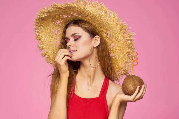 Kvinna med kokos cocktail i halm hatt exotisk semester sommar rosa bakgrund — Stockfoto