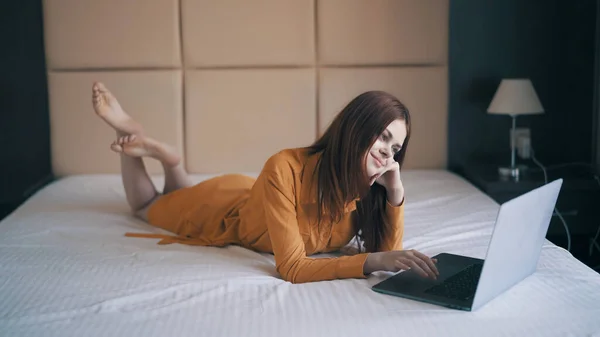 Vrouw werken terwijl liggend in bed in de voorkant van laptop internet — Stockfoto