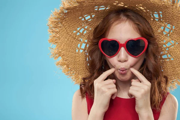 Chica en una playa Sombrero de paja en gafas de sol pelo rizado divertido fondo azul — Foto de Stock