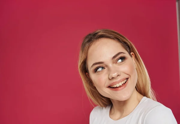 Mulher romântica em um fundo vermelho em uma camiseta branca Maquiagem no rosto sorriso — Fotografia de Stock