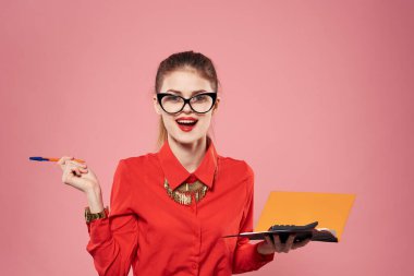 Zarif kadın kırmızı gömlekli sekreter pembe arka planı finanse ediyor