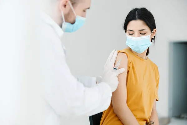 Professionell läkare håller sin hand på axeln av en kvinna covid vaccination — Stockfoto