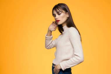 Sevimli esmer makyaj kırmızı dudaklar moda kıyafetler sarı arka plan