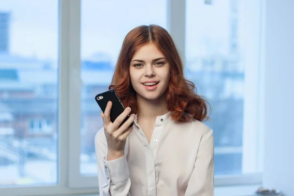 Hübsche Frau im Hemd mit Telefon in der Hand — Stockfoto