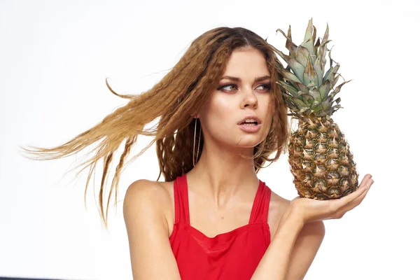 Mulher com abacaxi em mãos ondulado cabelo vermelho t-shirt frutas verão férias luz fundo — Fotografia de Stock